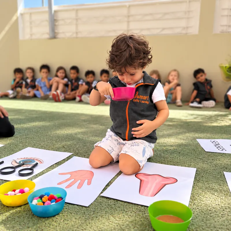 Enfant découvrant les cinq sens lors d'un atelier en plein air à la crèche B.smart