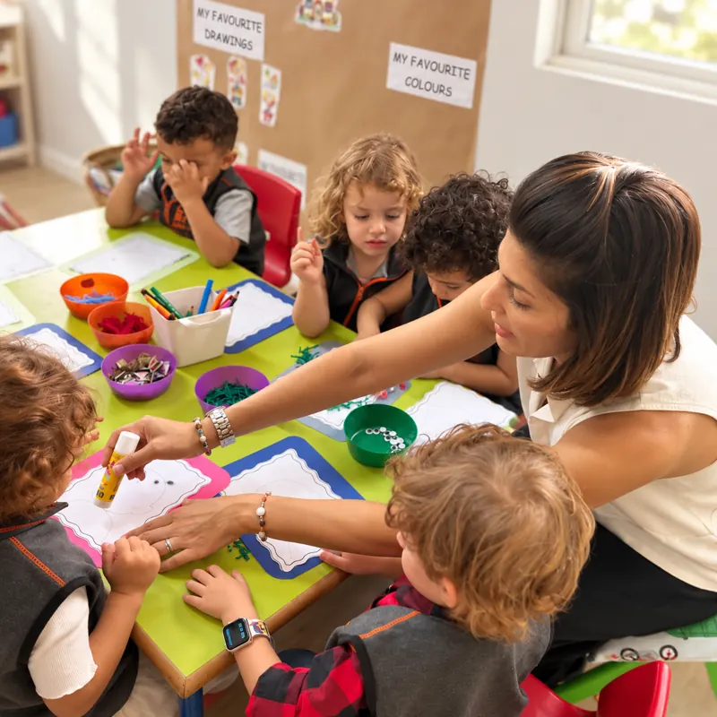 Atelier collage en petit groupe avec une éducatrice à la crèche B.smart