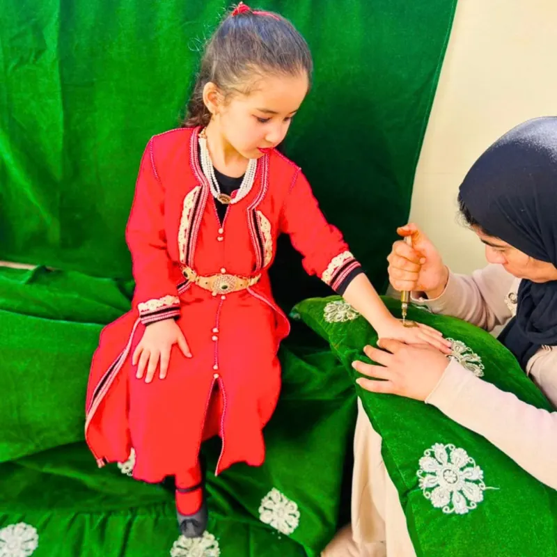 Fillette en caftan recevant du henné lors d'une fête traditionnelle à la crèche B.smart