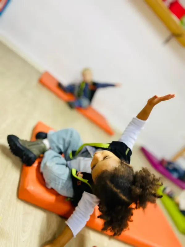 Fillette faisant du yoga sur un tapis en classe à la crèche B.smart